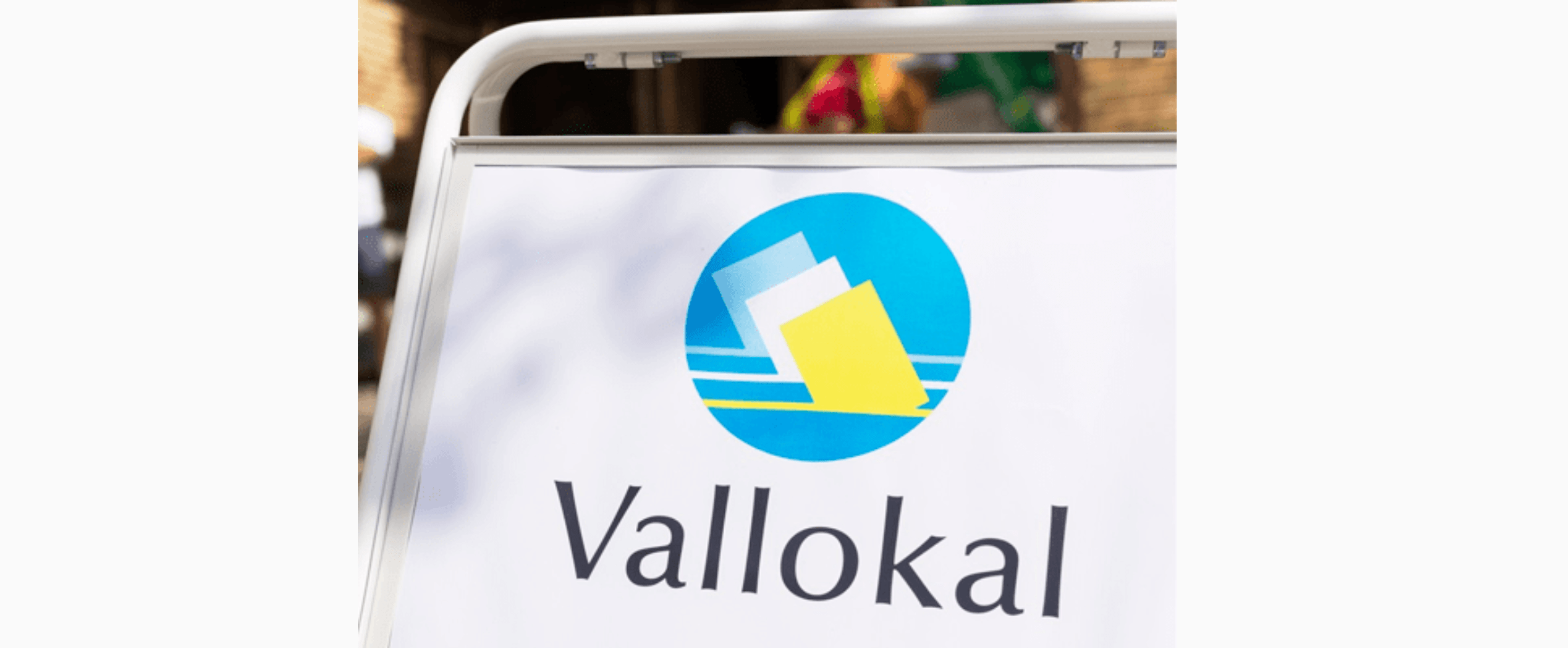 Vit skylt med svart text: "VALLOKAL".